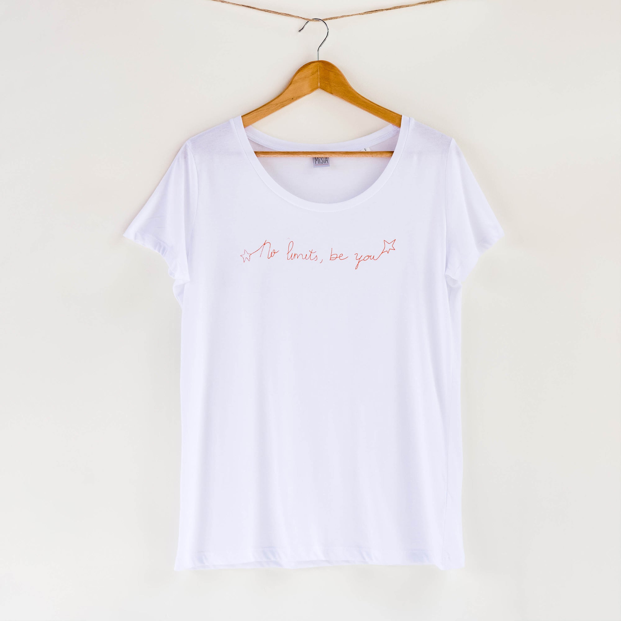 Camiseta blanca de mujer, de algodón orgánico y estampada a mano con tintas ecológicas. Texto estampado en color naranja.