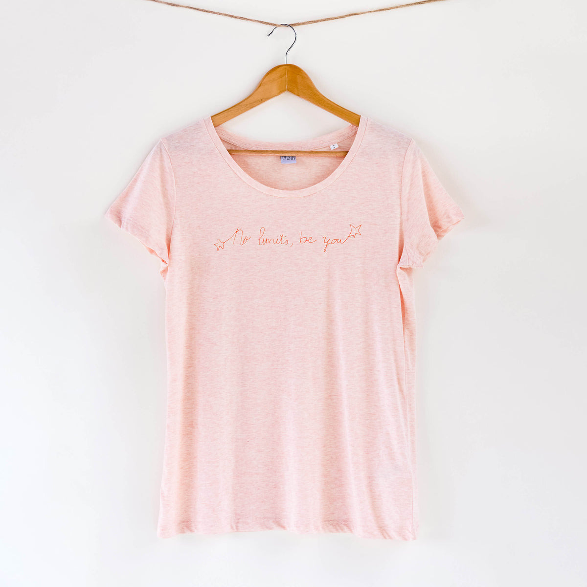 Camiseta rosa de mujer, de algodón orgánico y estampada a mano con tintas ecológicas. Texto estampado en color naranja.