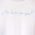 Detalle de texto estampado en color azul. Camiseta blanca de mujer, de algodón orgánico y etampada a mano con tintas ecológicas.