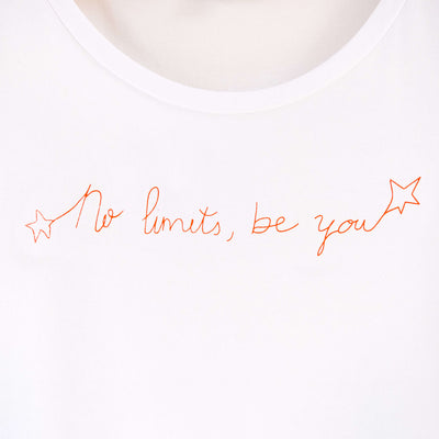 Detalle de texto estampado en color naranja. Camiseta blanca de mujer, de algodón orgánico y estampada a mano con tintas ecológicas.