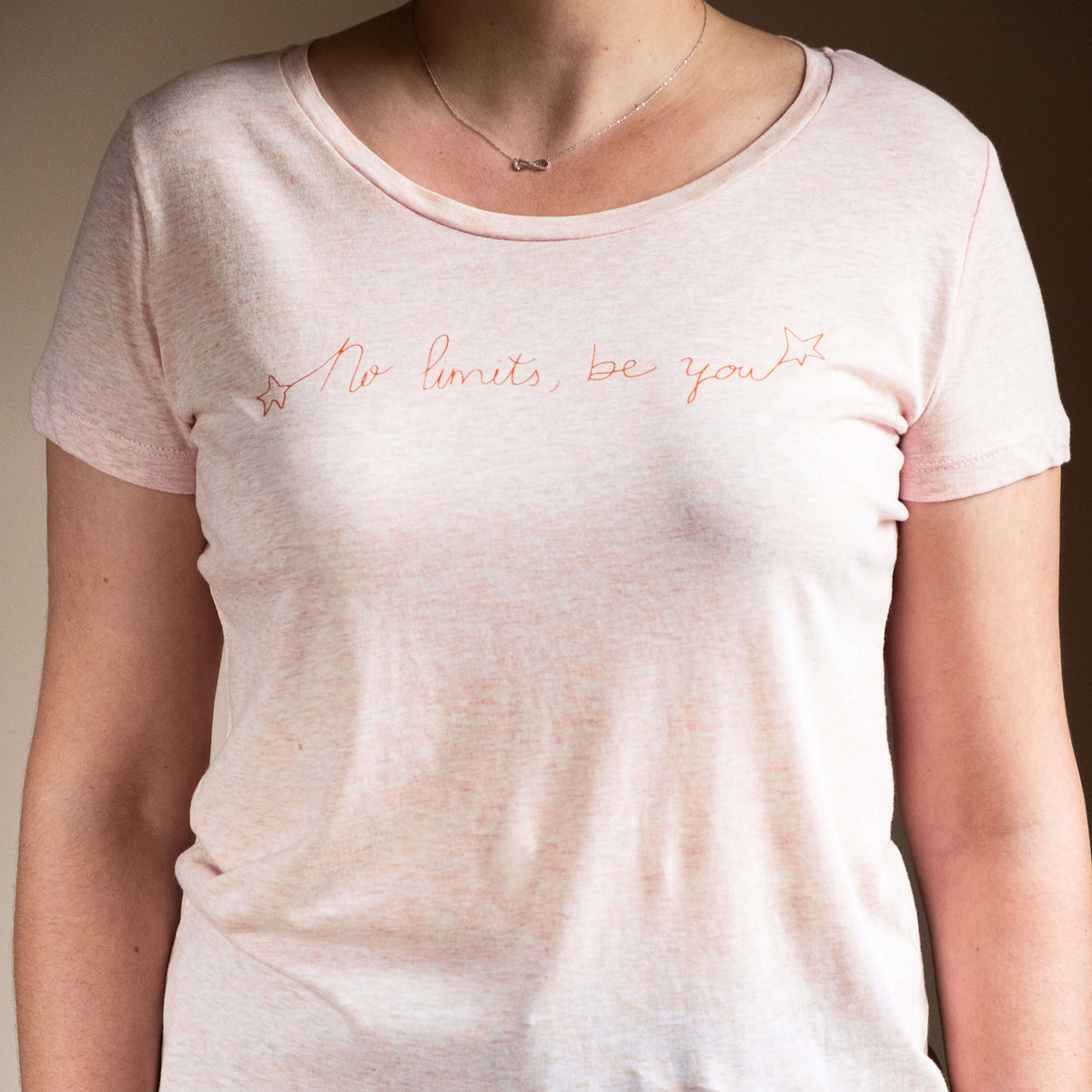 Camiseta rosa de algodón orgánico y serigrafiada a mano con tintas ecológicas. Texto serigrafiado en color naranja.
